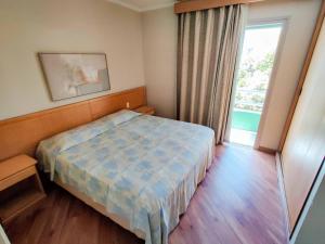 a small bedroom with a bed and a window at Residencial Bella Vista Suites in São Paulo