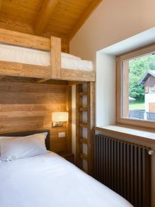 Pezzo的住宿－Chalet La mia Baita，一间卧室设有两张双层床和一扇窗户。
