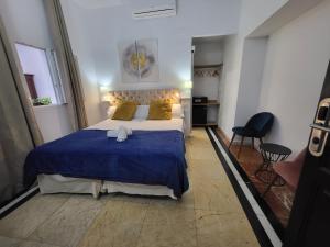 Un dormitorio con una cama grande con una manta azul. en Casona de San Andrés Boutique Hotel, en Sevilla