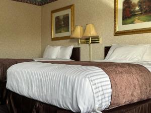a hotel room with two beds and two lamps at Rodeway Inn in Dalton