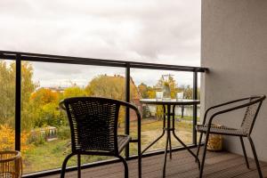 Un balcón con 2 sillas y una mesa en una terraza. en Chlebova z widokiem na Motławę - GYM i BAWIALNIA W CENIE, en Gdansk