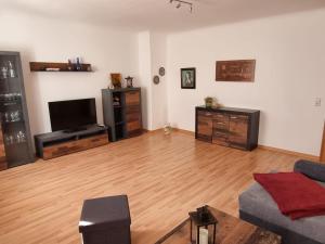 ein Wohnzimmer mit einem Sofa und einem Flachbild-TV in der Unterkunft Ferienwohnung Böttger in Dresden