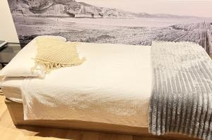 a bed in a bedroom with a painting on the wall at SMALL LUX BEACHCITY CLOSE to the RIVER,METRO AND PARKING in Bilbao