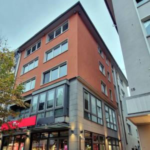 um edifício alto e vermelho com muitas janelas em Dark Jungle Suite: Seltersweg Netflix TV & Jumanji em Giessen