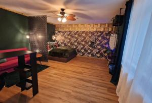 a living room with a bed and a ceiling fan at Dark Jungle - Innenstadt für 4 Netflix Switch Waschtrockner in Gießen