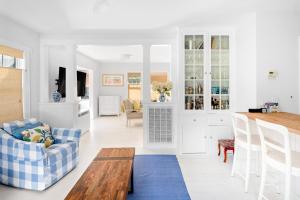 een keuken en een woonkamer met een bank en een tafel bij Blue Door Cottage in Cutchogue