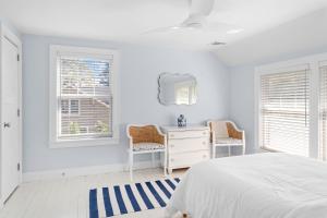een slaapkamer met een bed, een bureau en ramen bij Blue Door Cottage in Cutchogue