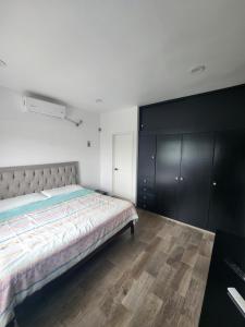- une chambre avec un grand lit et des armoires noires dans l'établissement habitaciones disponibles con baño privado zona centro, à Cunduacán