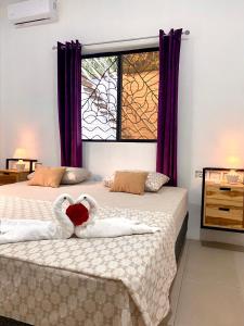 dwa łabędzie tworzące serce na dwóch łóżkach w sypialni w obiekcie Villa Ometepe w mieście Mérida