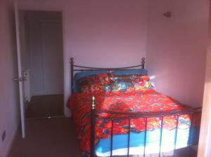 une chambre avec un lit avec une couette colorée dans l'établissement Lord Rod's Guest House, à Staines