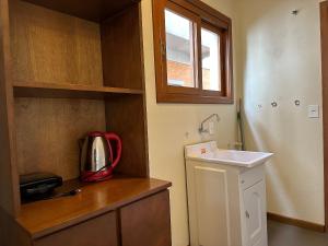 a small kitchen with a sink and a microwave at Apto Rua Coberta Gramado in Gramado +22 photos