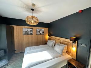 ein Schlafzimmer mit einem Bett und einem Kronleuchter in der Unterkunft Hotel Buren in West-Terschelling