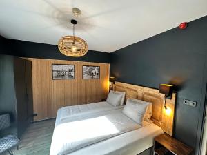 Schlafzimmer mit einem Bett und einem Kronleuchter in der Unterkunft Hotel Buren in West-Terschelling
