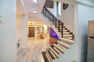 un escalier dans une maison aux murs blancs et au parquet dans l'établissement Zomak Villa 3BHK in Lonavala with pvt pool By Bungalows In Lonavala, à Lonavala