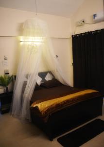 Schlafzimmer mit einem Bett mit Moskitonetz in der Unterkunft Mountainview Paradise in Karjat