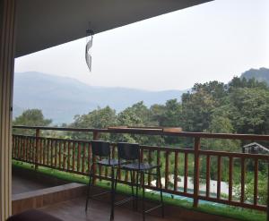 two chairs on a balcony with a view of the mountains at Mountainview Paradise in Karjat