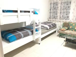 a bedroom with two bunk beds and a couch at Ferienwohnungen Honberg in Tuttlingen