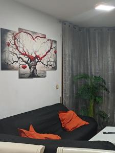 ein Schlafzimmer mit einem schwarzen Bett mit orangefarbenen Kissen und einem Baum in der Unterkunft Alojamiento Tierra del Ara in Boltaña