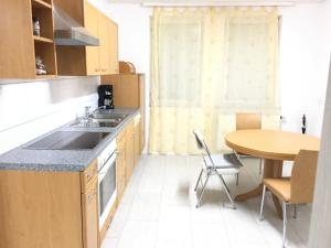 a kitchen with a table and a sink and a counter at Ferienwohnungen Honberg in Tuttlingen