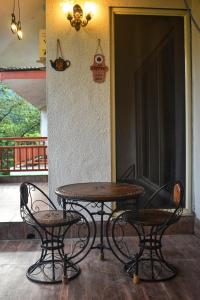 une table et deux chaises assises à côté d'une porte dans l'établissement Mountainview Paradise, à Karjat