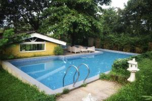 a swimming pool with two chairs and a house at Mountainview Paradise in Karjat