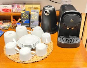 a tray of cups and plates next to a coffee maker at SMALL LUX BEACHCITY CLOSE to the RIVER,METRO AND PARKING in Bilbao