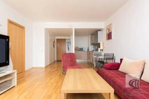 sala de estar con sofá rojo y mesa en Cozy 2-Bedroom Penthouse in the Heart of Tallinn en Tallin