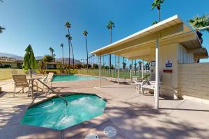 una piscina con un patio con mesa y sillas en Palm Desert Dream en Palm Desert