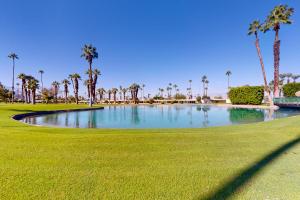 un estanque en un campo de golf con palmeras en Palm Desert Dream en Palm Desert