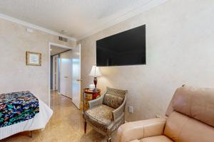 Sala de estar con sofá, silla y TV en Palm Desert Dream en Palm Desert