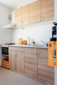 a kitchen with wooden cabinets and a sink at Premium Studio next to National Arena & Park in Bucharest