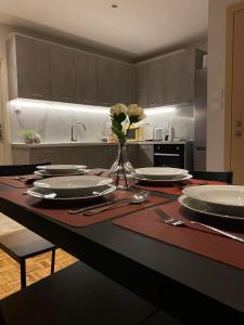 a kitchen with a table with plates and flowers on it at Lydia's City View Apartment in Ioannina