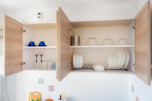 a cupboard filled with plates and dishes at Premium Studio next to National Arena & Park in Bucharest