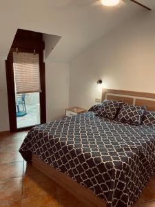 1 dormitorio con 1 cama y ventana con silla en Alojamientos Mestanza, en Baños de la Encina