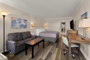 a hotel room with a bed and a couch and a desk at Atlantic Oceanside Dewey in Dewey Beach