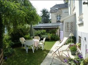 un jardín con mesa, sillas y sombrilla en Chambre d'hôte Jules & Annette, en Vittel