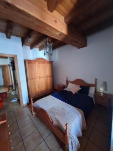um quarto com uma cama num quarto com tectos em madeira em Hostal el patio restaurante em San Bartolomé de Pinares