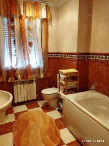 a bathroom with a tub and a toilet and a sink at Los Avellanos de Santillana in Queveda
