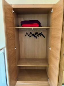 un armario con estanterías de madera y perchas en Lotf alquiler valencia en Burjasot