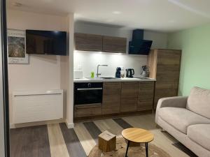 a small living room with a couch and a kitchen at L'étape de Marcel - Aymé in Avoine