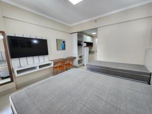 a room with a flat screen tv and a couch at Spazzio diRoma - Apartamentos JN in Caldas Novas