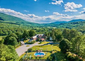 eine Luftansicht auf ein großes Grundstück mit Pool und Bergen in der Unterkunft Wilburton Inn in Manchester