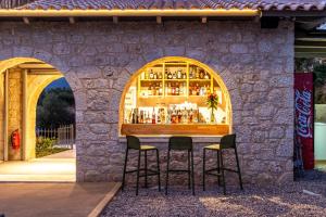 a bar in a stone wall with two stools at Olympia Zervea Studios with Pool - Apartment in Kardamili