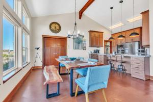 a kitchen with a wooden table and blue chairs at Dream Weaver House with Hot Tub and Ocean View! in Manchester