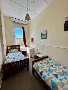 una camera con due letti e una finestra di Chalet Backpackers a Dunedin