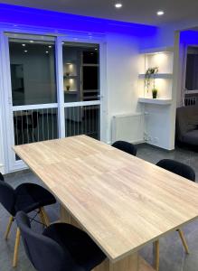 una mesa de madera y sillas en la sala de estar. en Charmant t3 avec balcon, en Saint-Fons