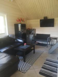 ein Wohnzimmer mit einem Sofa und einem Tisch in der Unterkunft Verknės slėnis in Aukštadvaris