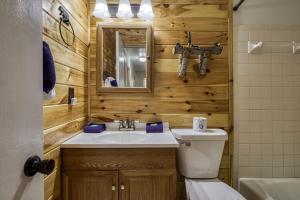 a bathroom with a sink and a toilet and a mirror at Four Bears Den, Free Attraction Tickets, Hot Tub, Arcade Game, Gatlinburg, WIFI!!! in Gatlinburg +47 photos