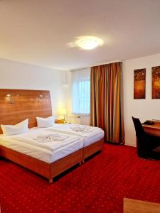 ein Schlafzimmer mit einem großen Bett und einem roten Teppich in der Unterkunft Hotel Kaiser in Berlin