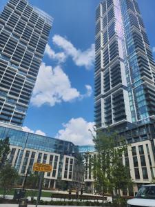 dos edificios altos en una ciudad con un cartel delante en Aethestic Apartment 2bedroom unit, en Vaughan